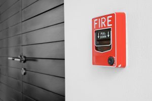 color fire alarm switch on black and white wall