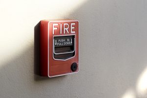 red fire alarm box on cement wall background